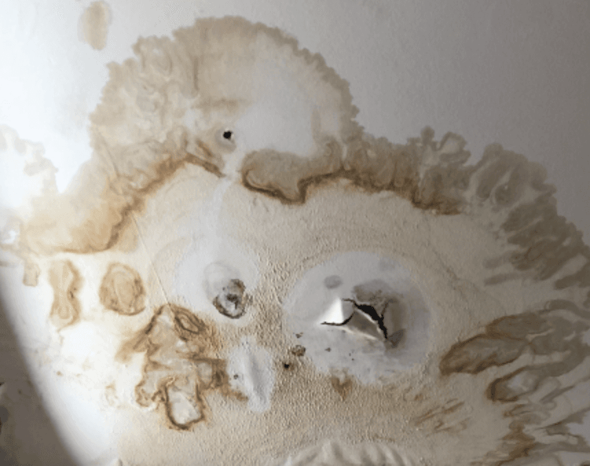 Water-stained drywall ceiling around a light fixture