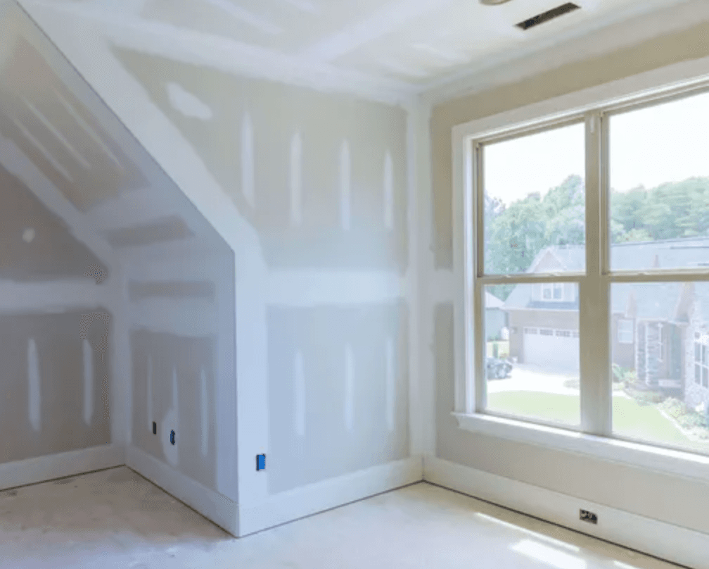 Bedroom with new drywall taped and ready for finishing